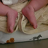 James joined the competition — help win amazing prizes! baby, feet, toes, blanket, knitted_blanket, fabric, lion_illustration, zebra_illustration, infant, skin, closeup, texture, soft, bed, sleeping_area, cute, newborn, resting, cozy, pattern