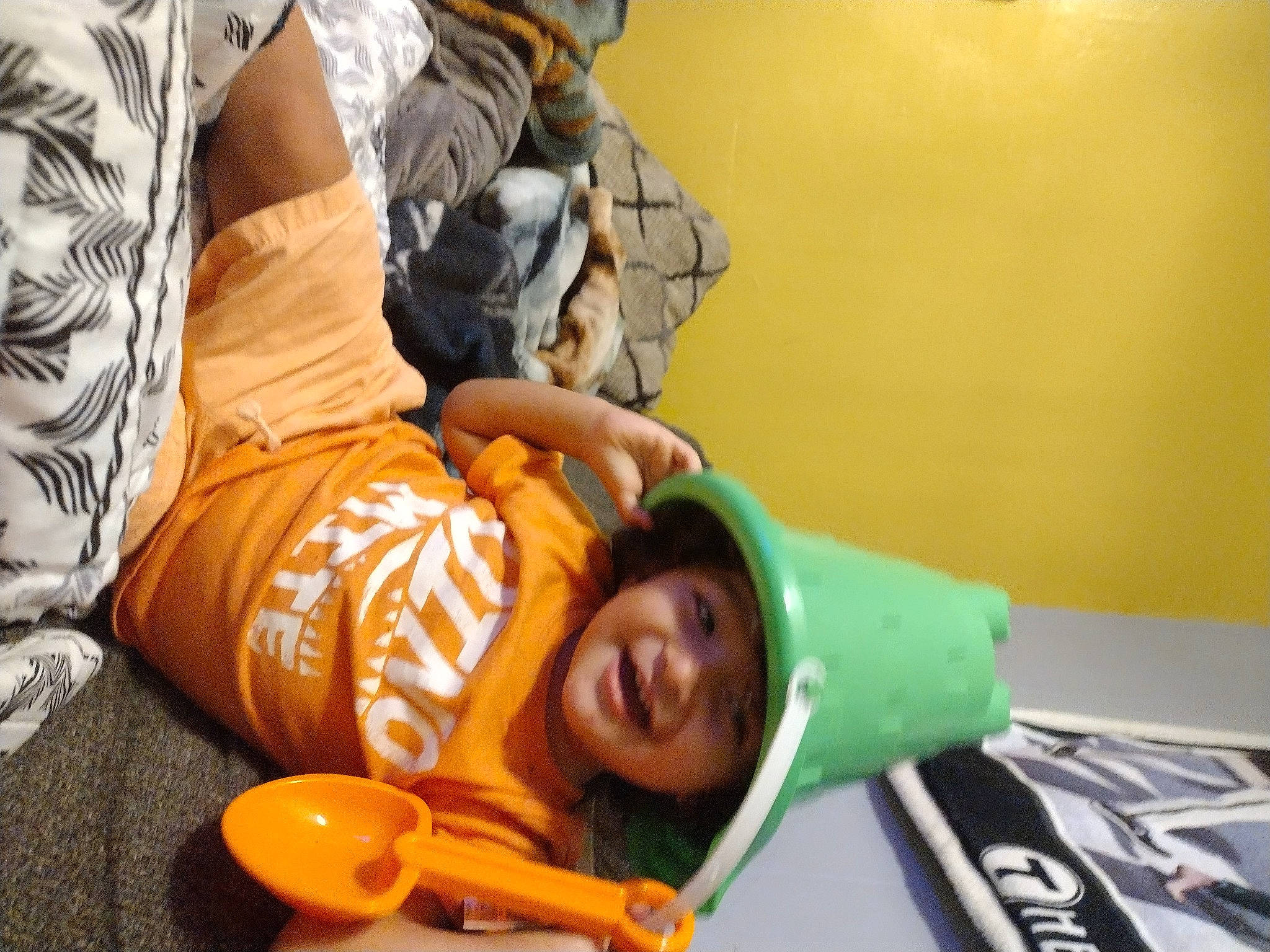 Neven is registered to the contest to win money with this photo: child, comfort, fun, happy, hat, headwear, leisure, orange, person, personal_protective_equipment, recreation, sitting, smile, t_shirt, yellow