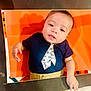 Khylae joined the competition — help win amazing prizes! baby, infant, child, orange_background, navy_blue_shirt, tie_design, khaki_pants, cute, portrait, face, eyes, hand, lying_down, clothing, expression, indoor, photo_frame, skin, curious, young