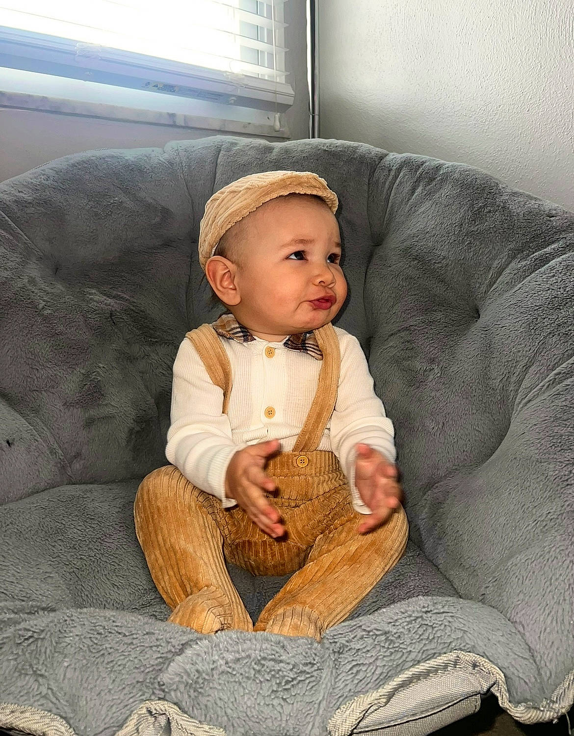 Laron is registered to the contest to win money with this photo: baby, baby_toddler_clothing, cap, chair, cheek, child, comfort, costume_hat, couch, eye, face, fur, hat, head, lap, person, sitting, sleeve, toddler, window