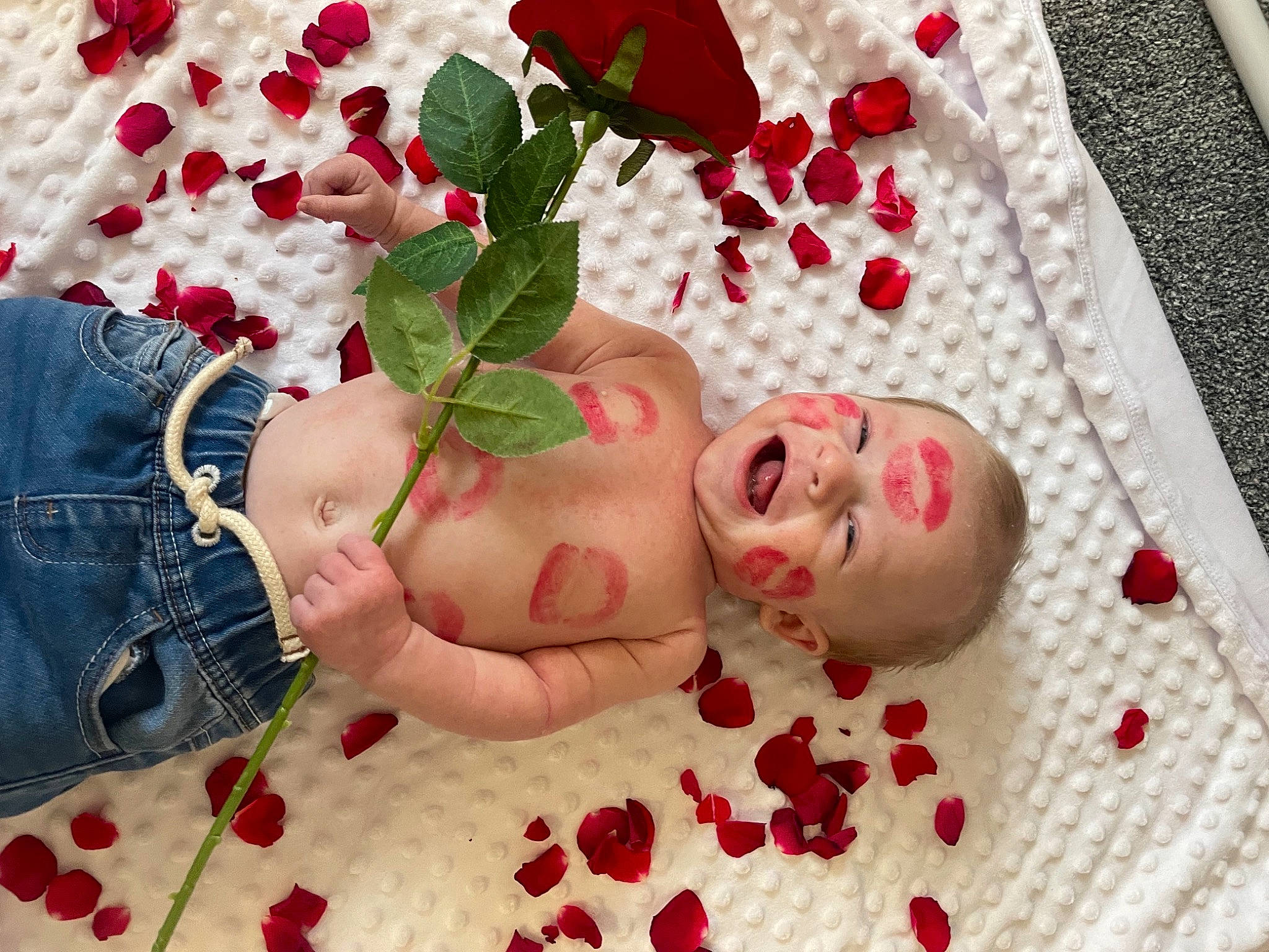 Albi is registered to the contest to win money with this photo: arm, baby, chest, child, facial_expression, finger, flower, hand, happy, leg, mouth, nail, pattern, person, petal, pink, plant, red, skin, thigh