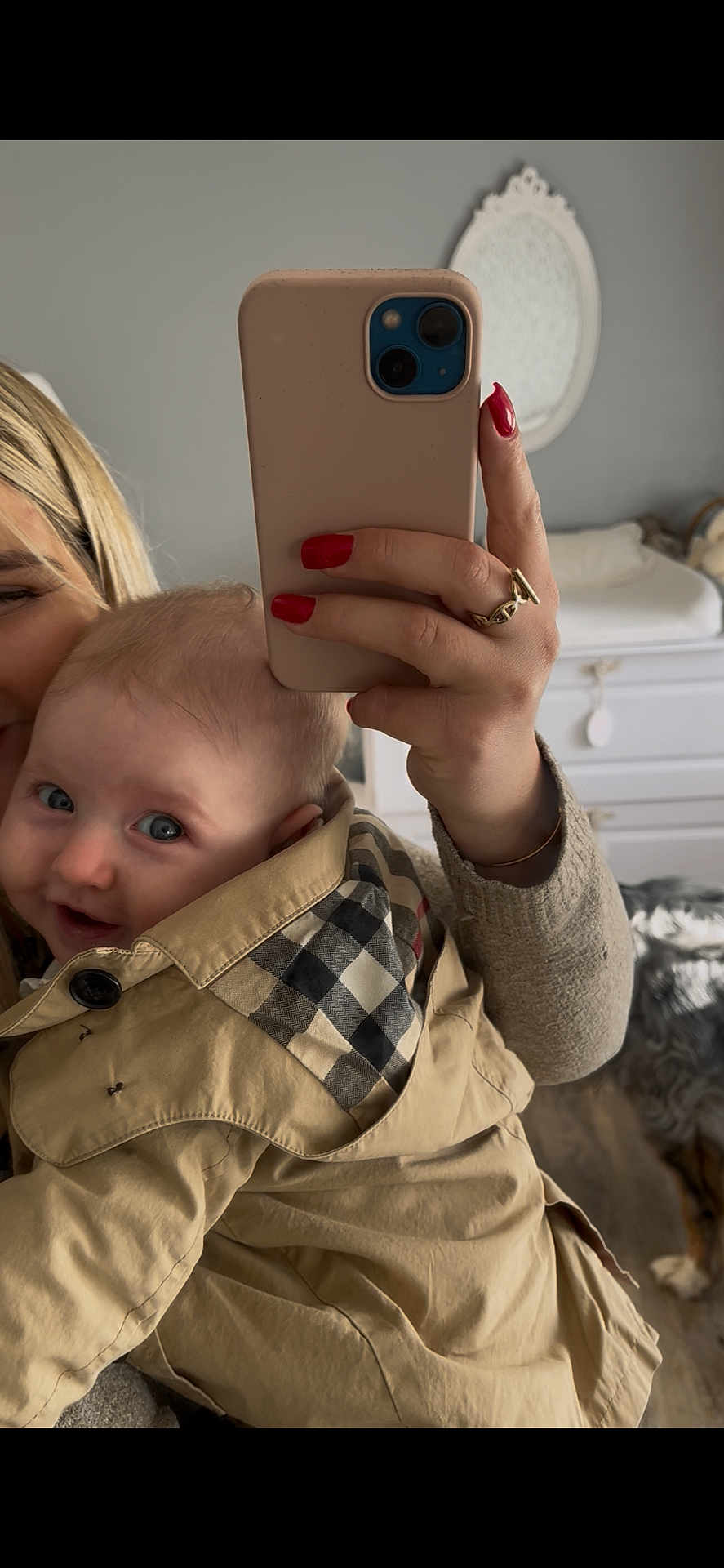 Gabrielle a rejoint le concours — aidez-le/la à gagner de superbes lots ! baby, child, person, selfie, smartphone, jacket, beige, checkered_pattern, hand, red_nail_polish, mirror, dresser, indoor, smile, face, portrait, closeup, warm_light, home, cozy
