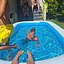 child, pool, water, splashing, yellow_shorts, swimming, backyard, porch, people, steps, towel, greenery, sunlight, summer, legs, toes, happy, outdoor, fun, family