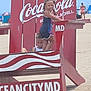 Raylynn joined the competition — help win amazing prizes! child, children, beach, lifeguard_chair, red, coca_cola, sand, summer, outdoor, play, fun, person, people, sunny, vacation, ocean_city_md, braids, clothing, standing, sitting