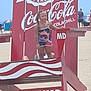 child, beach, lifeguard_chair, red, coca_cola, ocean_city_md, summer, sand, braids, outdoor, advertisement, people, vacation, sunny, clothing, portrait, standing, tourists, boardwalk, fun