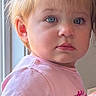 toddler, child, portrait, blue_eyes, pink_shirt, hair_buns, indoor, window_light, curious, person, face, cute, young_child, casual_clothing, soft_light, expression, skin, hair, closeup, childhood