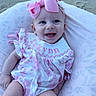 baby, infant, smile, pink_bow, floral_dress, pillow, sand, happy, cute, child, person, outdoor, portrait, headband, clothing, baby_girl, eyes, skin, face, babywear