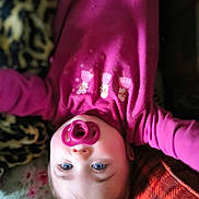 Rhaenyra joined the competition — help win amazing prizes! baby, pacifier, blue_eyes, pink_clothing, blanket, lying_down, cute, infant, face, child, soft_texture, warm_colors, cozy, indoors, portrait, young_child, sleepwear, close_up, expression, comfort