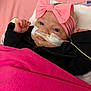 baby, infant, child, pink_blanket, pink_headband, bow, face, nasal_tube, medical_tape, black_jacket, lying_down, hospital, bed, blanket, cute, expression, person, indoors, closeup, portrait