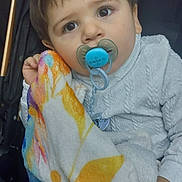 Mylan participe au concours pour gagner de l'argent avec cette photo : baby, child, pacifier, blanket, stroller, white_sweater, cute, infant, portrait, closeup, young_child, comfort, hand, face, indoors, clothing, person, expression, soft, warm
