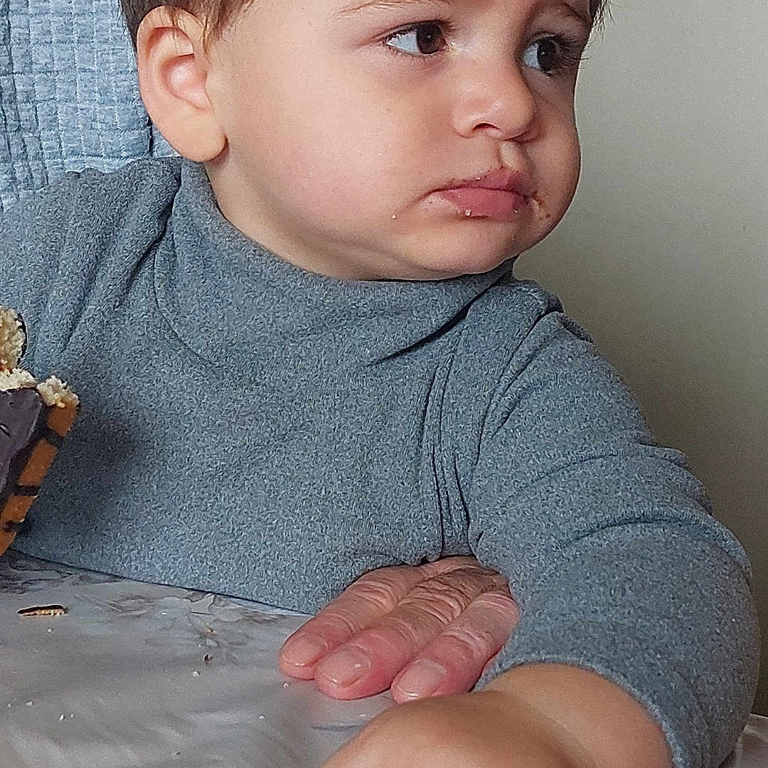 Mylan a rejoint le concours — aidez-le/la à gagner de superbes lots ! child, chocolate, closeup, clothing, emotion, expression, face, food, furniture, gray_sweater, hair, hand, indoor, napkin, person, portrait, skin, snack, table, toddler