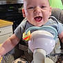 baby, infant, smiling, high_chair, breast_pump, kitchen, adult, man, cabinet, appliance, countertop, clothing, face, person, happy, indoor, furniture, table, sitting, parent