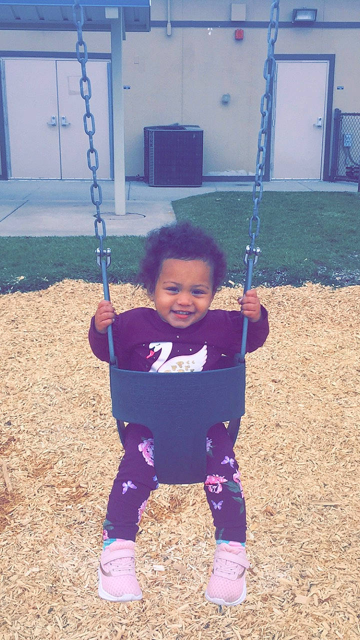 Jazlyn joined the competition — help win amazing prizes! child, joy, outdoor_play_equipment, person, play, playground, public_space, recreation, smile, swing, toddler