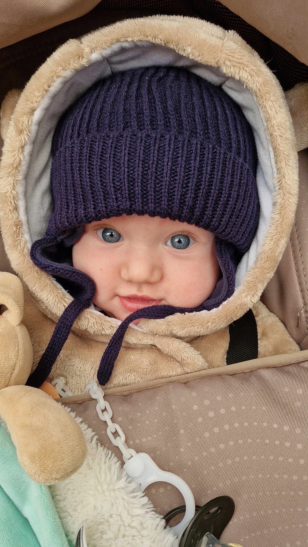 Alméo a rejoint le concours — aidez-le/la à gagner de superbes lots ! baby, infant, face, hat, knit_hat, blue_eyes, jacket, fuzzy, plush_toy, pacifier, chain, clothing, closeup, portrait, cute, child, warm, cozy, baby_carrier, smile