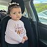 Iris joined the competition — help win amazing prizes! toddler, child, car_seat, car_interior, sweater, bow, blue_eyes, curly_hair, pink_sweater, window, daylight, vehicle, seatbelt, portrait, serious_expression, clothing, person, young_child, car_door, outdoor_view