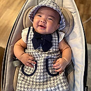 Emma joined the competition — help win amazing prizes! baby, infant, smiling, tweed_dress, hat, baby_seat, cushion, comfortable, happy, cute, chubby_cheeks, indoor, wooden_floor, clothing, child, portrait, person, adorable, seat, fashion