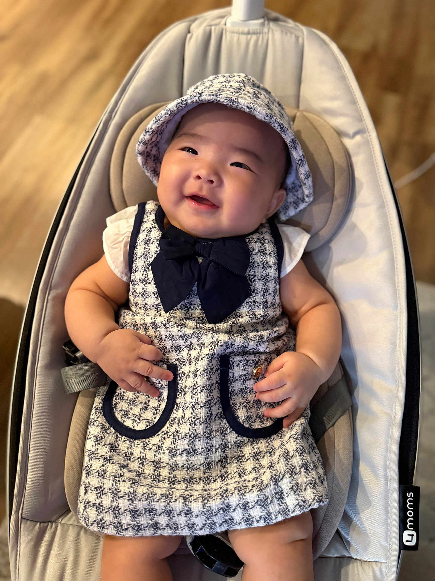 Emma joined the competition — help win amazing prizes! baby, infant, smiling, tweed_dress, hat, baby_seat, cushion, comfortable, happy, cute, chubby_cheeks, indoor, wooden_floor, clothing, child, portrait, person, adorable, seat, fashion