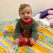 Leandro a rejoint le concours — aidez-le/la à gagner de superbes lots ! baby, child, smiling, sitting, clothing, bed, blanket, happy, indoor, portrait, person, cute, infant, colorful, festive, patterned, young_child, face, hands, feet