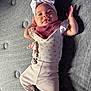 baby, infant, headband, clothing, pink, gray, texture, shadow, lying_down, cute, child, person, soft_light, indoor, legs, arms, face, expression, fabric, comfort