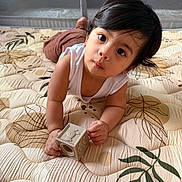 Dylan John is registered to the contest to win money with this photo: toddler, child, toy, block, indoor, quilt, pattern, curious, face, hands, brown_hair, white_shirt, play, floor, crawling, cute, expression, looking_up, skin, infant
