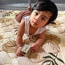 toddler, child, toy, block, indoor, quilt, pattern, curious, face, hands, brown_hair, white_shirt, play, floor, crawling, cute, expression, looking_up, skin, infant