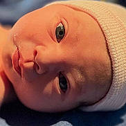Heidi joined the competition — help win amazing prizes! newborn, baby, infant, face, closeup, cap, blue_blanket, skin, eyes, headwear, soft_lighting, portrait, lying_down, cute, child, small, young, sleepy, indoors, warm