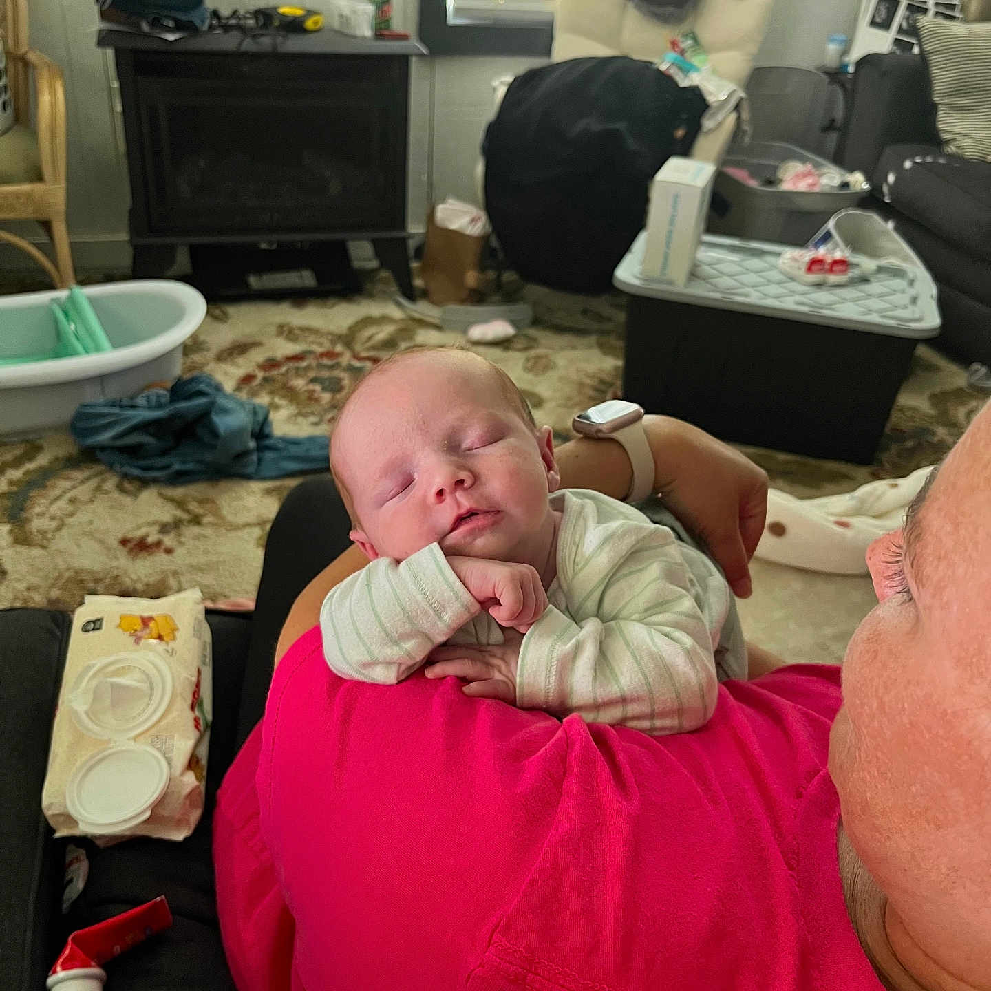 Ottalee Jo is registered to the contest to win money with this photo: baby, sleeping, adult, shoulder, pink_shirt, indoor, living_room, window, blinds, carpet, furniture, diaper_wipes, bottle, blanket, person, face, head, relaxation, cozy, home