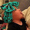 Ottalee Jo joined the competition — help win amazing prizes! baby, child, headband, turquoise, patterned, face, profile, infant, black_clothing, cushion, plaid_blanket, cozy, indoor, curious, person, portrait, closeup, soft_lighting, baby_girl, seated