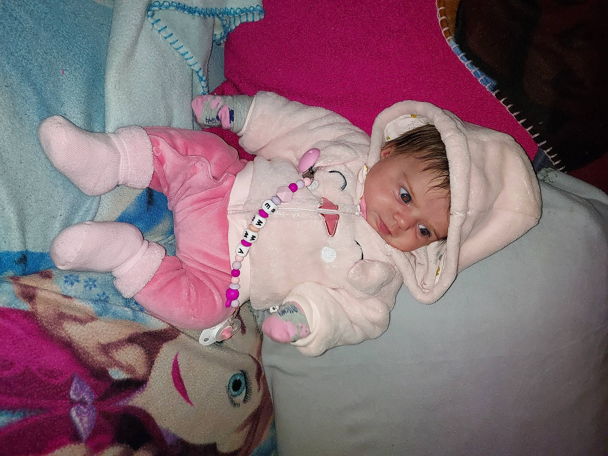 Emma a rejoint le concours — aidez-le/la à gagner de superbes lots ! baby, baby_products, baby_sleeping, baby_toddler_clothing, cheek, child, comfort, finger, hand, lap, linens, magenta, nail, pattern, person, pink, room, sitting, skin, thumb