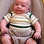 baby, infant, child, smiling, striped_clothing, onesie, seat, baby_seat, patterned_fabric, chubby_cheeks, cute, relaxed, indoor, portrait, person, human, young, comfort, soft_lighting, happy