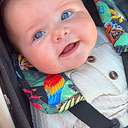 Sacha a rejoint le concours — aidez-le/la à gagner de superbes lots ! baby, smiling, close_up, blue_eyes, stroller, harness, colorful, parrot_pattern, knitted_outfit, cute, child, infant, sitting, safety_belt, portrait, happy, face, skin, young_child, outdoor