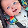 baby, smiling, close_up, blue_eyes, stroller, harness, colorful, parrot_pattern, knitted_outfit, cute, child, infant, sitting, safety_belt, portrait, happy, face, skin, young_child, outdoor