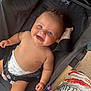 Sacha participe au concours pour gagner de l'argent avec cette photo : baby, smiling, diaper, stroller, blue_eyes, harness, chubby_cheeks, happy, child, infant, seated, outdoor, person, clothing, fabric, pattern, colorful, black, skin, cute