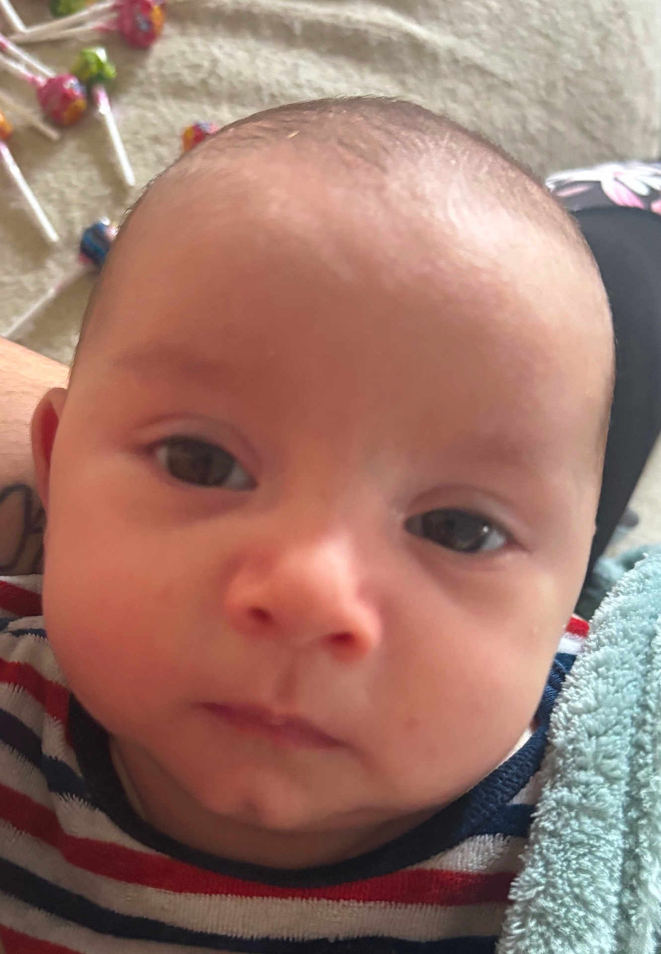 Luciano a rejoint le concours — aidez-le/la à gagner de superbes lots ! baby, face, closeup, striped_shirt, infant, child, blanket, lollipop, candy, indoor, portrait, cute, young_child, soft_texture, head, expression, person, skin, eyes, nose
