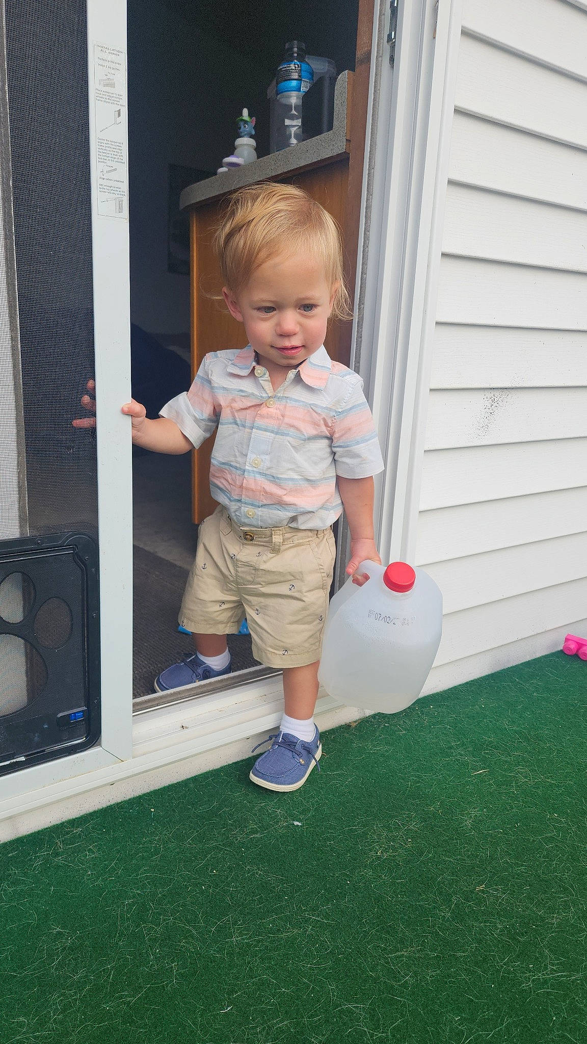 Buckley is registered to the contest to win money with this photo: baby_toddler_clothing, calf, child, door, flooring, fun, games, grass, home, home_door, human_leg, knee, party_supply, person, play, recreation, shorts, t_shirt, toddler, wood