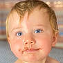 baby, bare_shoulders, blue_eyes, child, chocolate, close_up, curly_hair, cute, expression, face, hair, indoors, messy_face, person, portrait, skin, smile, soft_background, toddler, young