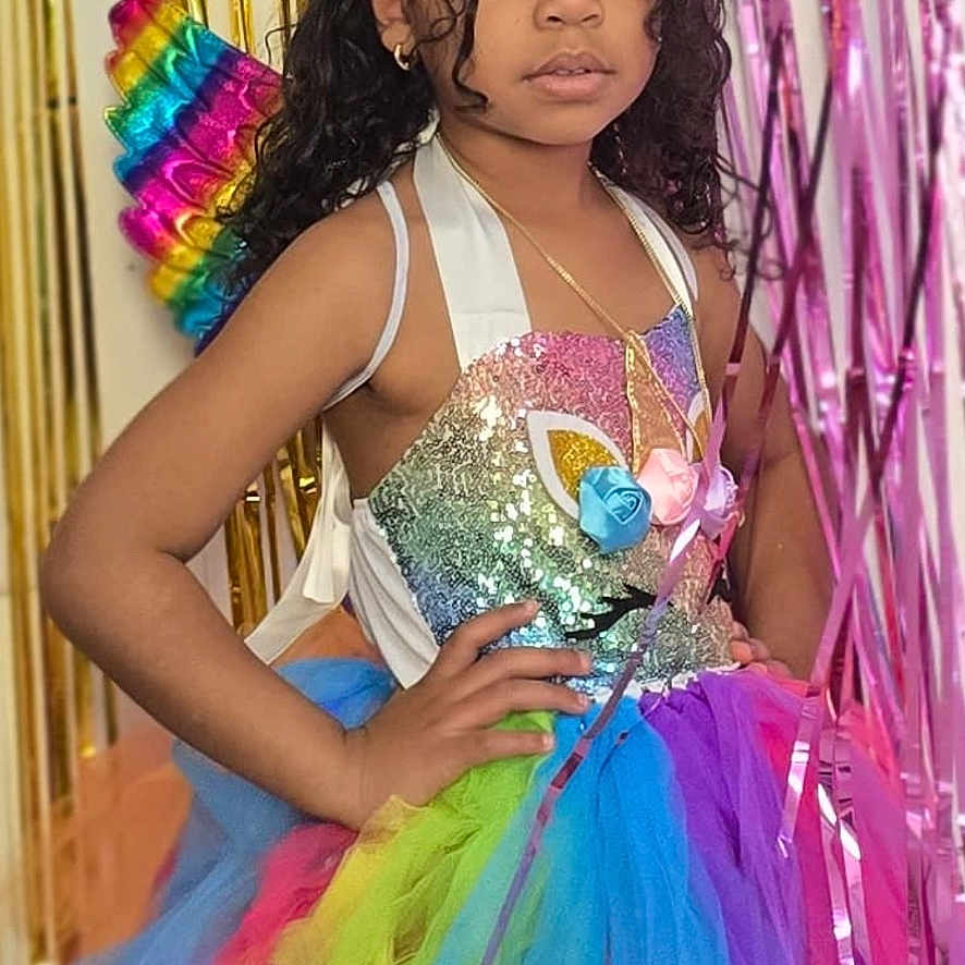 Anaya joined the competition — help win amazing prizes! child, girl, portrait, birthday, costume, unicorn, fairy, rainbow, tutu, dress, sparkles, glitter, wings, party_hat, headband, curly_hair, smiling, posing, party_decorations, colorful