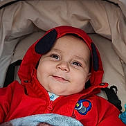Elianno a rejoint le concours — aidez-le/la à gagner de superbes lots ! baby, child, smile, hoodie, red_clothing, blanket, stroller, face, infant, happy, cute, portrait, baby_girl, baby_boy, outdoor, bundle_up, warm, cozy, clothing, person