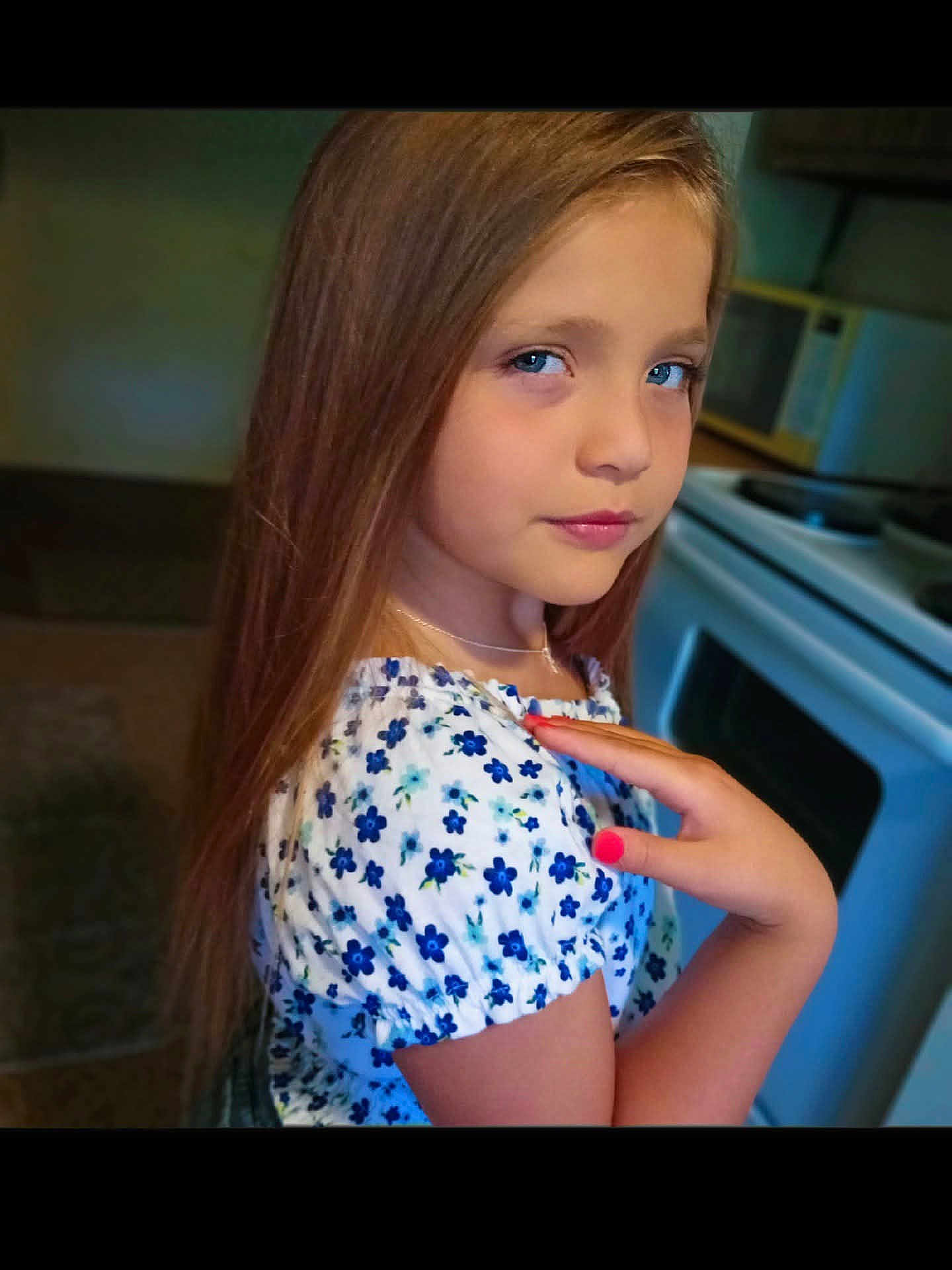 Kaylee joined the competition — help win amazing prizes! child, girl, blue_eyes, long_hair, floral_clothing, hand, nail_polish, kitchen, stove, microwave, appliance, portrait, indoor, person, young, casual, fashion, looking_at_camera, standing, calm_expression