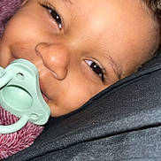 Carmelo joined the competition — help win amazing prizes! baby, close_up, pacifier, curly_hair, blanket, smiling, face, infant, child, lying_down, cozy, skin, happy, portrait, young_child, indoors, head, comfort, expression, person
