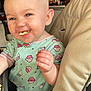 Haisleigh is registered to the contest to win money with this photo: baby, child, high_chair, food, eating, onesie, cupcake_pattern, smiling, happy, indoor, kitchen, face, hand, blue_eyes, short_hair, infant, cute, messy, portrait, seat