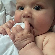 Haisleigh is registered to the contest to win money with this photo: baby, infant, face, hand, fingers, blanket, skin, closeup, cheeks, curious, expression, soft, cuteness, child, newborn, bed, sleeping_area, indoors, person, portrait