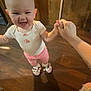 baby, child, indoor, wooden_floor, holding_hands, smiling, pink_pants, animal_slippers, white_shirt, person, happy, footwear, floor, hand, head, face, home, cute, support, standing