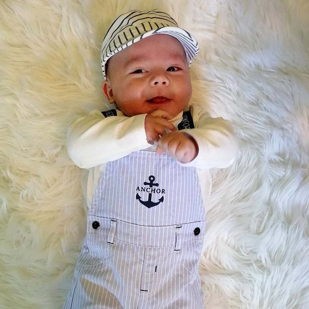 Saveriu participe au concours pour gagner de l'argent avec cette photo : baby, baby_products, baby_sleeping, baby_toddler_clothing, beanie, cap, child, comfort, face, fur, gesture, hand, happy, headwear, linens, person, sleeve, smile, t_shirt, textile