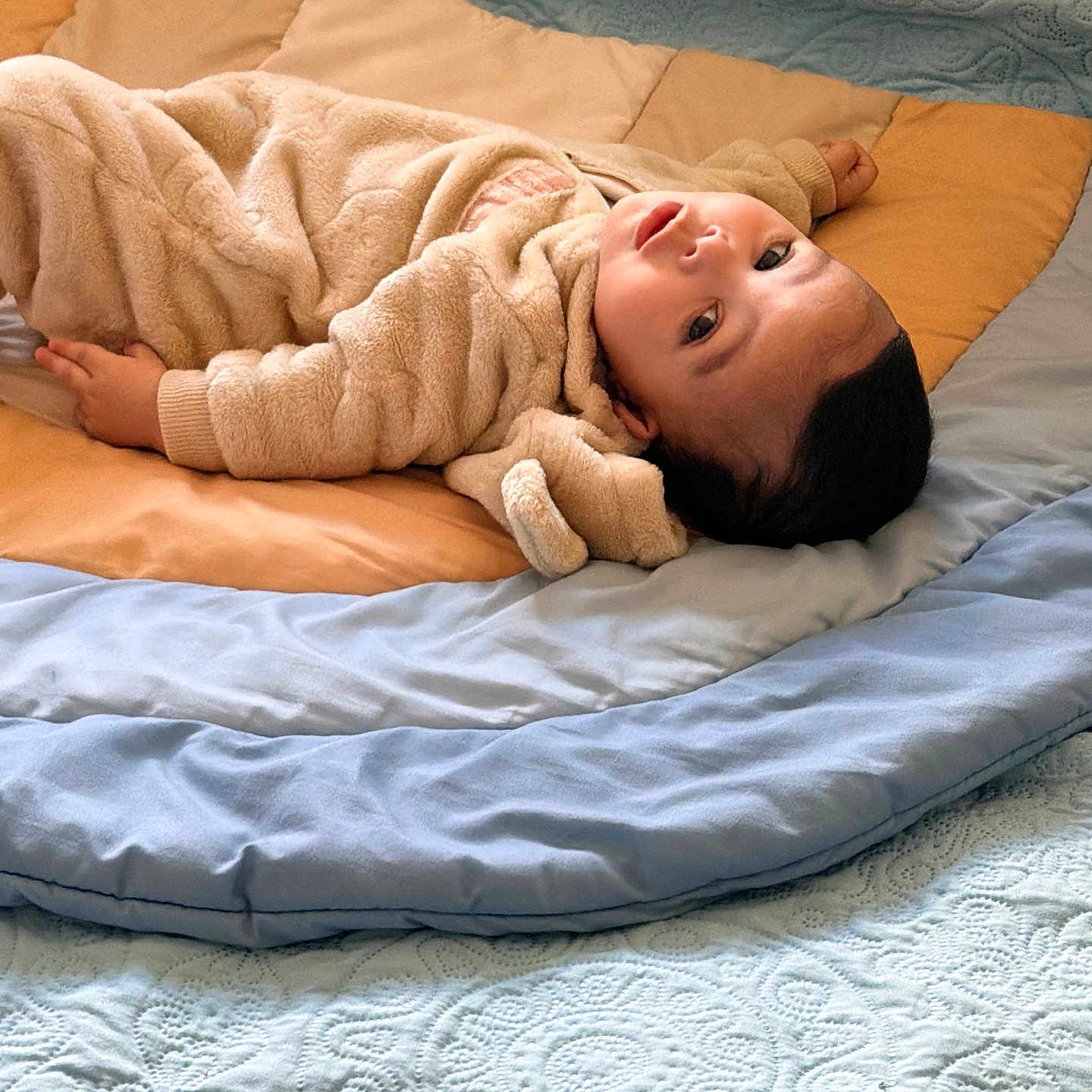 Yasser is registered to the contest to win money with this photo: baby, bed, blanket, child, clothing, cute, eyes, fabric, face, fingers, head, indoor, infant, laying_down, portrait, quilt, relaxed, sleepwear, soft_texture, warm