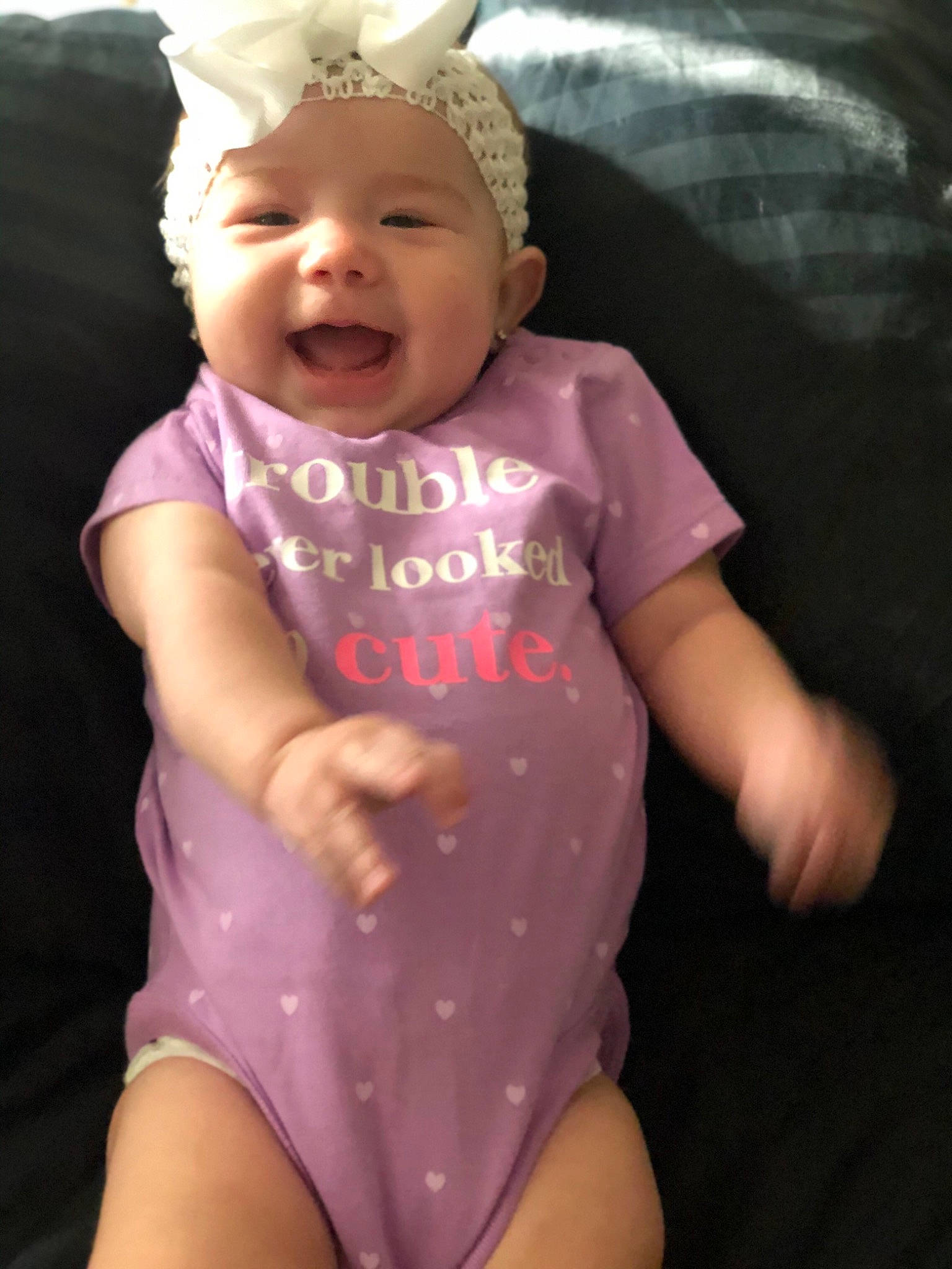 Paisley is registered to the contest to win money with this photo: baby, baby_toddler_clothing, cap, cool, eye, facial_expression, finger, gesture, hand, happy, headwear, human_body, lip, mouth, organ, person, pink, skin, sleeve, smile