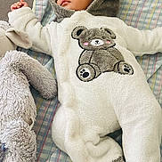 Antonio participe au concours pour gagner de l'argent avec cette photo : baby, sleeping, onesie, bear_design, plush, stuffed_animal, blanket, cozy, infant, cute, soft, child, lying_down, indoors, warm_clothing, headwear, sleep, peaceful, toddler, fabric