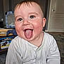 baby, child, tongue_out, white_clothing, onesie, happy, face, head, indoor, room, clock, carpet, furniture, hand, skin, tongue, person, smile, eyes, hair