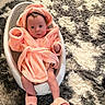 baby, infant, robe, bath_seat, footwear, fluffy, soft_texture, carpet, indoor, child, cute, pink, white, gray, sitting, portrait, cozy, warm, person, home