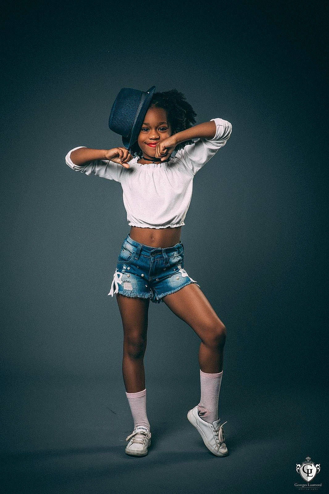 Djayana participe au concours pour gagner de l'argent avec cette photo : arm, black_hair, dance, elbow, electric_blue, entertainment, eye, fashion_design, flash_photography, gesture, happy, hat, human_leg, joy, knee, performing_arts, person, sleeve, sun_hat, t_shirt